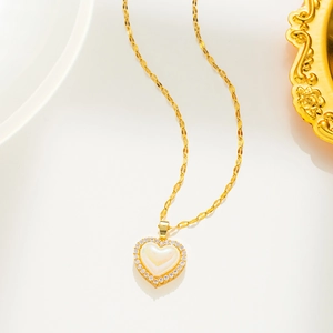 Detail of gold titanium heart necklace with iridescent pearl center and crystal halo