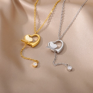 Detail of gold and silver heart butterfly necklaces with zircon drop on champagne silk