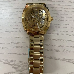 Detailed close-up of golden skeleton automatic mechanical watch on a wood background
