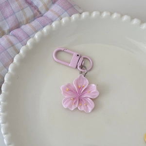Detailansicht eines rosa Kirschblüten-Schlüsselanhängers auf einer Keramikschale