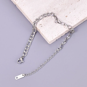 Macro view of silver titanium steel bracelet featuring Figaro chain with lobster clasp