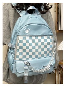 Detail view of light blue backpack with transparent checkerboard layer and acrylic chain