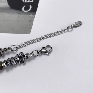 Detail shot of stainless steel lobster clasp and natural brown tiger eye bead on bracelet