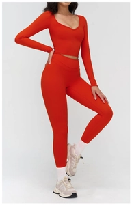 Détail du haut de yoga orange à col en V et legging avec tissu extensible ergonomique