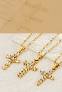 Detailed close-up of gold cross necklaces with sparkling zircon inlay and fine chain craftsmanship