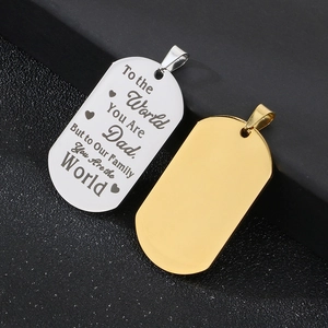 Macro shot of silver engraved dog tag and gold blank pendant on dark textured surface