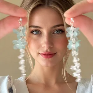 Macro detail of long tassel shell earrings with blue flower design and beaded accents