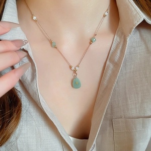 Détail du collier avec pendentif goutte en pierre verte et étoile dorée incrustée