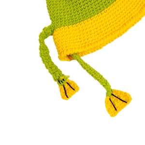 Detailed close-up of green and yellow knitted frog hat with handmade crochet texture