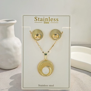 Detailed macro view of gold stainless steel necklace and earrings with textured rings