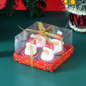 Close-up of 4-pack Santa Claus scented candle set in transparent gift box with gold ribbon
