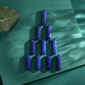 Detailed view of ten polished hexagonal lapis lazuli crystal points on a textured green background