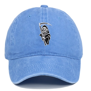Close-up of the detailed Grim Reaper embroidery on a light blue washed cotton baseball cap
