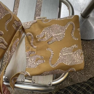 Détail du sac en toile jaune moutarde avec imprimé animal abstrait et fermoir aimanté