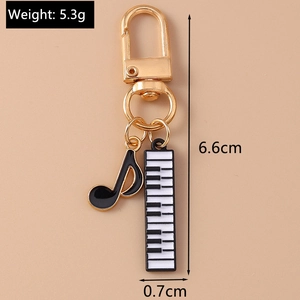 Detail view of music keychain with piano keys and note charms including size dimensions