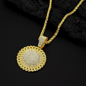Close-up of gold iced-out round pendant with clear rhinestones on black charcoal