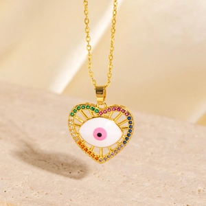 Macro detail of gold-plated heart pendant with evil eye and multicolor crystals
