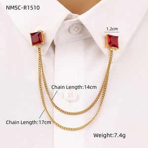 Detail of square red zircon collar pin with double gold chains on white shirt
