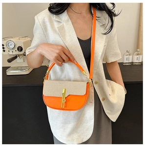 Detail showing orange leather and beige woven fabric textures with a gold metal clasp