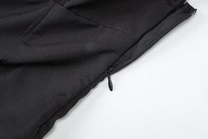 Close-up of the concealed side zipper on a black slim-fit dress with ribbed fabric detail