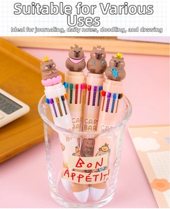 Close-up of four Capybara 10-color pens in a glass cup with desk accessories