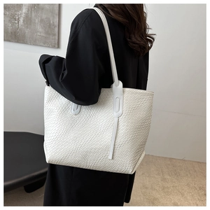 Gros plan détaillé du sac cabas blanc en cuir tressé avec bandoulière élégante
