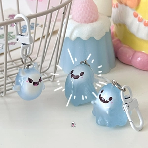 Close-up of three cute blue luminous ghost keychains with matte finish and plastic hooks