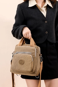 Détail d'un sac à langer en nylon kaki avec poignées tissées et bandoulière amovible