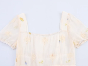 Detailansicht des quadratischen Ausschnitts und der Blumenstickerei am Kleid