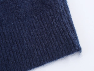 Detailed macro shot of navy blue knit cardigan texture with soft fuzzy fibers and ribbed edges