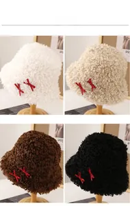 Détail de bobs en peluche en quatre couleurs avec de jolis nœuds rouges à pois blancs