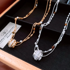 Close-up of double-layer necklace with zircon cylinder pendant and elegant pearls
