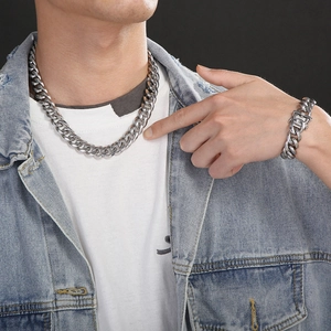 Ensemble collier et bracelet à mailles cubaines argentées porté sur une veste