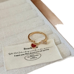 Bague dorée avec pendentif cœur rouge et étoile scintillante dans son coffret