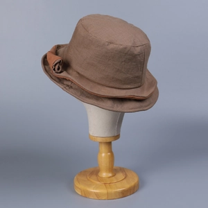 Detailed view of the linen bucket hat brim featuring natural fiber texture and decorative folds