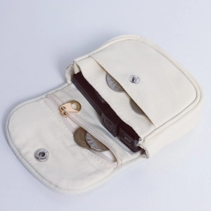 Detail view of the cream canvas laptop pouch showing its internal compartments and storage