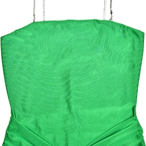 Detailed close-up of green satin top with elegant metal chain straps and pleated chest design