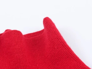 Dettaglio ravvicinato della maglia rossa morbida con trama in fibra delicata