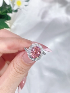 Close-up of pink oval gemstone S925 silver ring with sparkling crystal halo inlay
