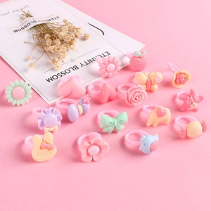 Set of colorful plastic kids rings featuring cute flower and animal shapes on pink background