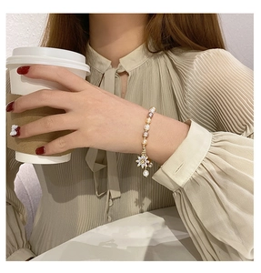 Detailed shot of fresh pearl bracelet with micro-pave zircon sunflower pendant