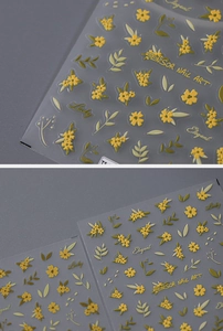 Detailed close-up of 3D embossed floral nail stickers with yellow flowers and gold lettering