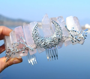 Macro detail of handmade rose quartz crystal crown with silver moon and twig elements