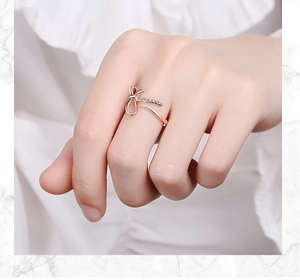 Close-up of rose gold bow ring with micro-pave crystals on female hand