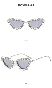 Close-up of cat-eye sunglasses with silver metal frames and crystal rhinestone embellishments