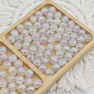 Detail of 10mm iridescent cracked glass beads for DIY jewelry making in a wooden tray