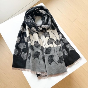 Close-up of winter scarf featuring ginkgo leaf patterns and elegant fringe details