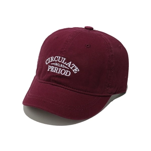 Close-up of burgundy cotton baseball cap featuring white embroidered letters on white background