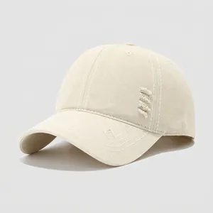 Detalle de gorra infantil de algodón beige con efecto desgastado y costuras blancas