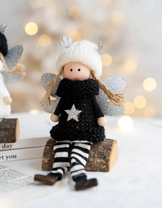 Detail of Christmas angel doll with black star sweater and silver glitter wings
